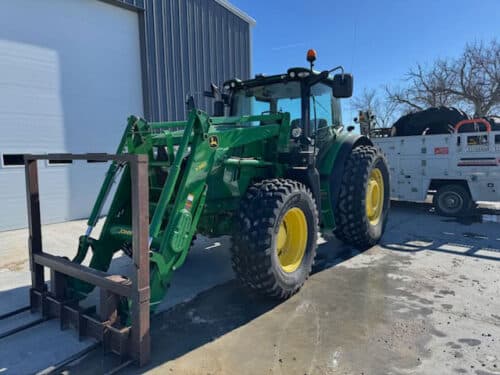 John Deere tractor with MDR 1000 tires and a forklift attachment on the front. 
